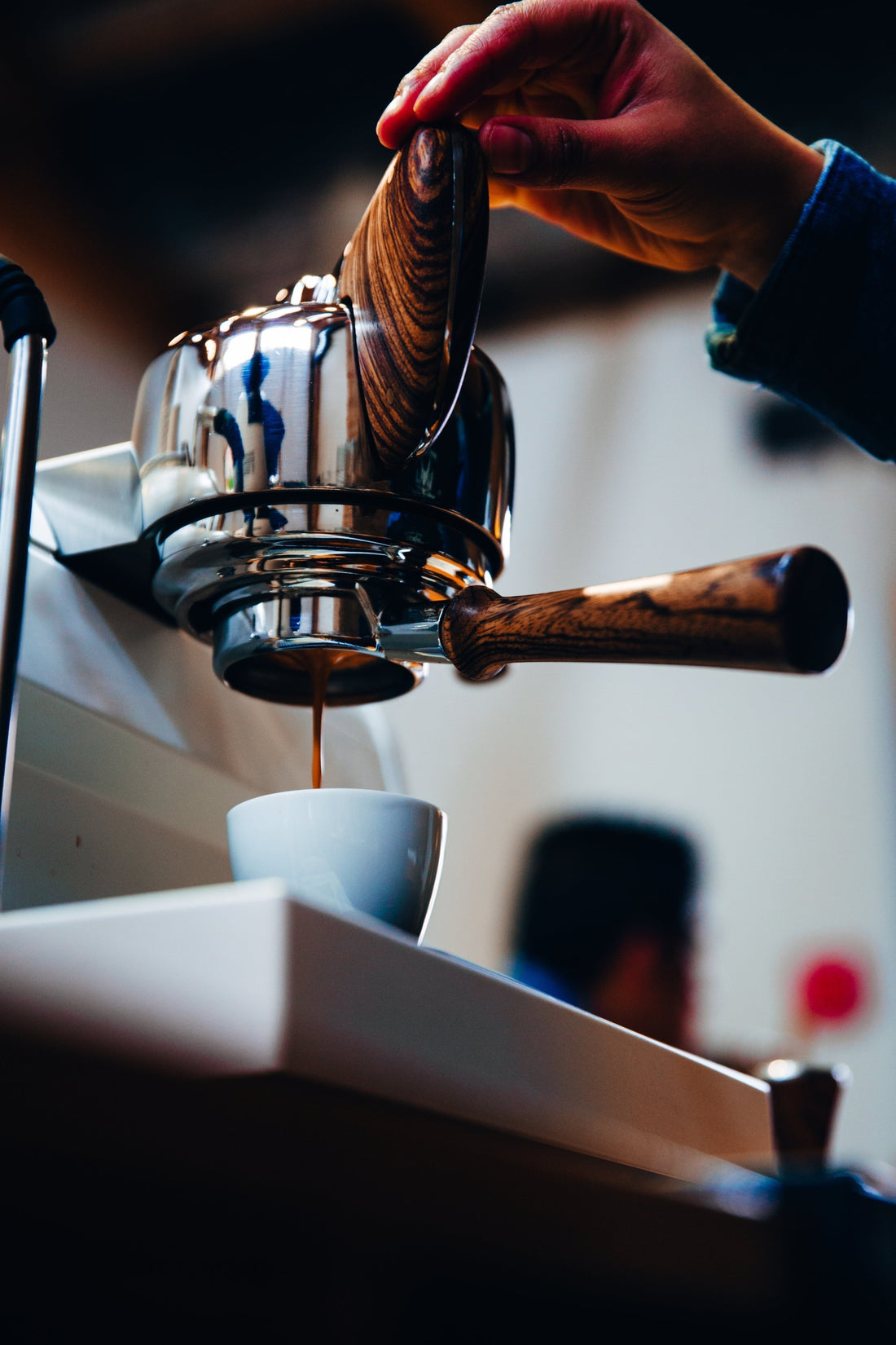 A person extracting a coffee with an espresso machine